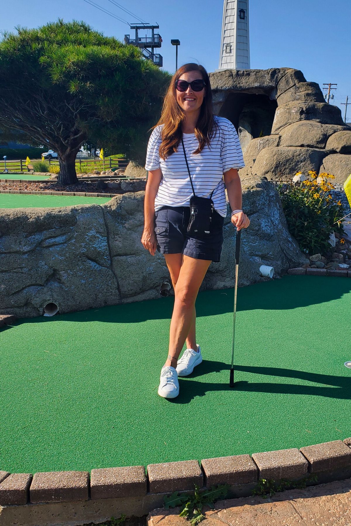 woman standing on a miniature golf course leaning on a golf club at Geneva on the Lake