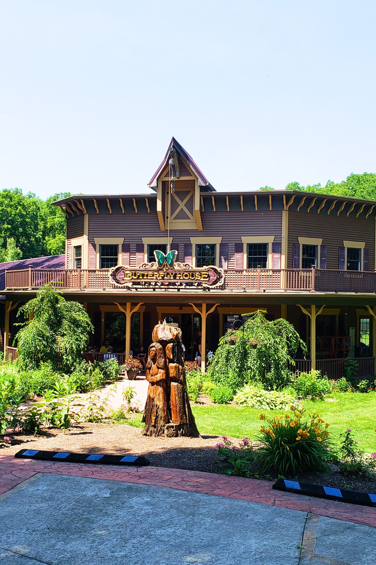 outside of butterfly house at put in bay with a wood statue of a woman out front