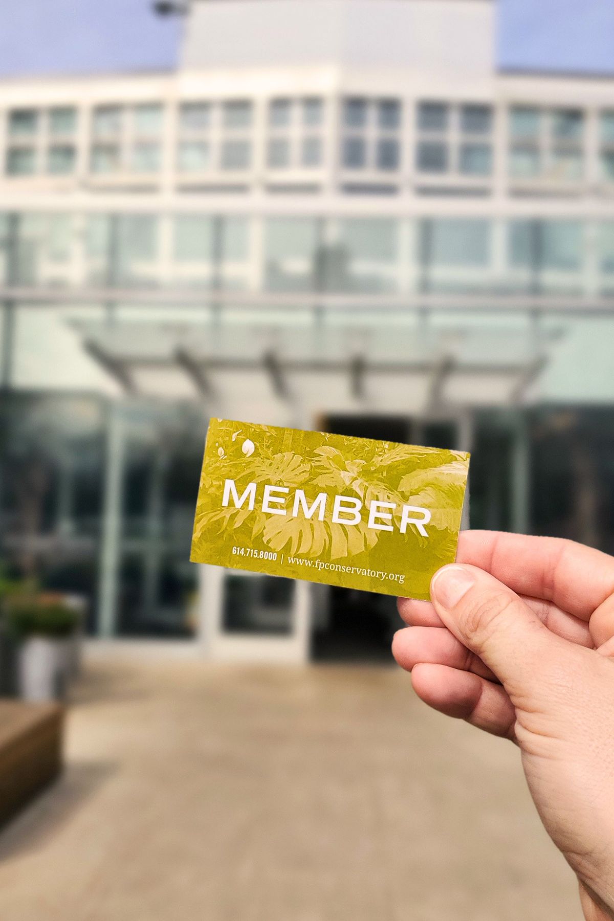 holding a borrowed membership from the library in front of Franklin Park Conservatory