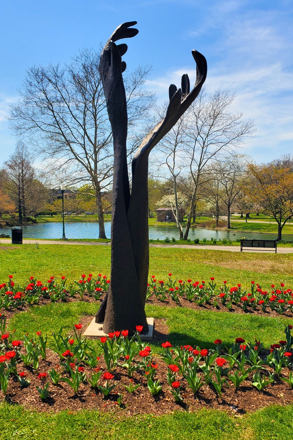 hands sculpture in the middle of red tulips outside at Franklin Park